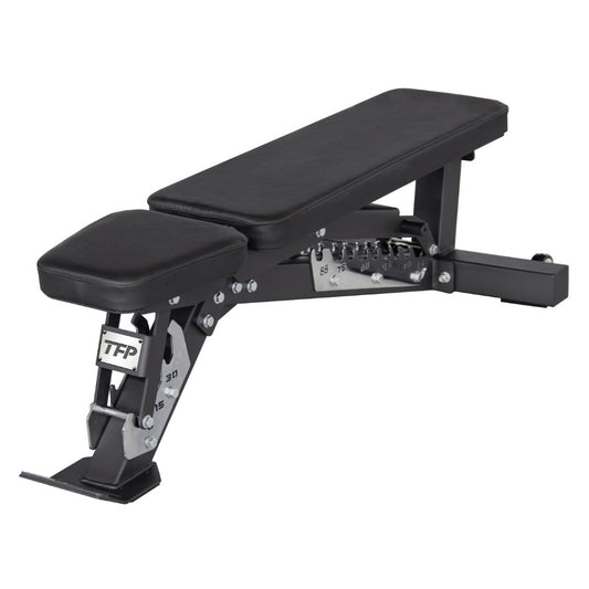 A black adjustable weight bench with a padded headrest and long inclined bench pad, shown on a plain white background. The frame is black metal with silver adjustment hardware, and the brand name TFP Fitness is visible on the leg support.