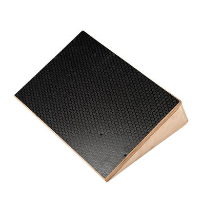 A rectangular wedge-shaped wooden riser or ramp with a black honeycomb-patterned top surface, shown on a plain white background.